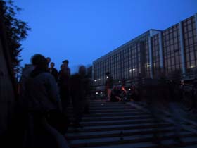 Foto von der Party: Menschen stehen und sitzen auf der Treppe zur Tunnelröhre, im Hintergrund der Palast der Republik